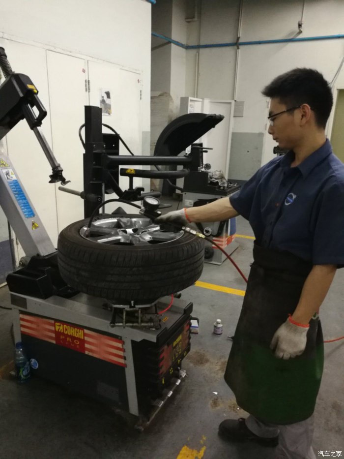 天津4s店里熟练的修理工正在为补胎后的轮胎充气.