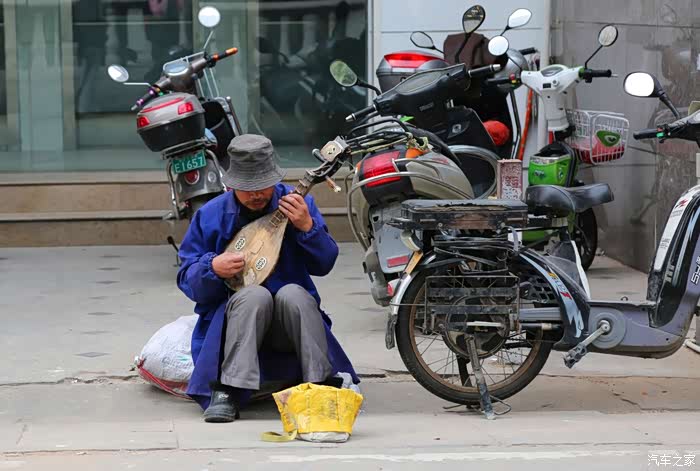 街边的个卖艺人,他演唱的像是河南梆子